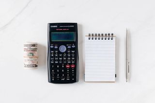 A calculator and notepad to convert weekly travel pay