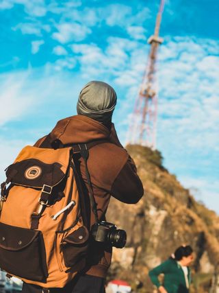 Backpacking travel healthcare professional looking up at mountain